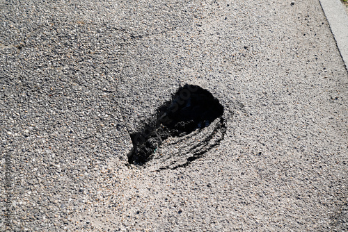 Fototapeta Naklejka Na Ścianę i Meble -  crack close up of a potholer small sinkhole in grey asphalt pavement street city