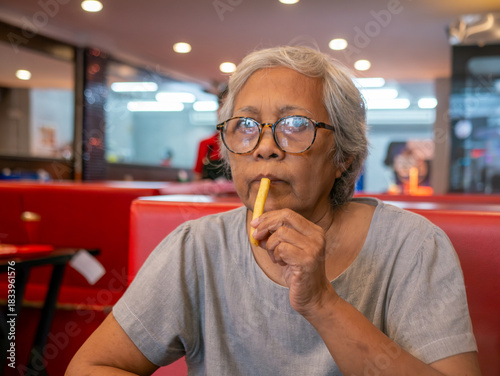 Asian Senior Woman Eating French Fries Enjoying Fast Food Meal Elderly Lifestyle Portrait
