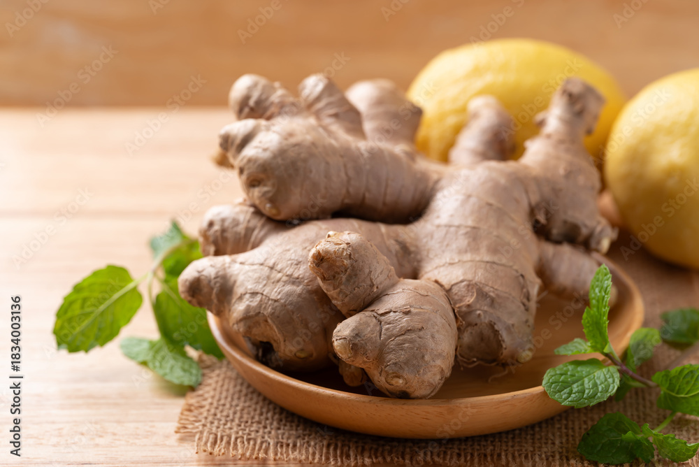 Fototapeta premium Fresh ginger, lemon and mint leaf on wooden background