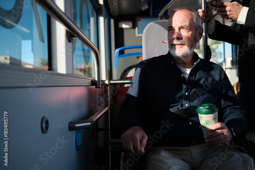 Senior man commuting on bus, looking out window