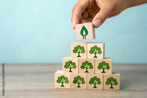 Hand placing a leaf block atop a tree block pyramid for environmental growth