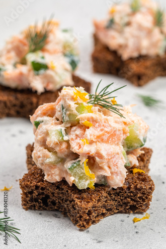 Sourdough bread topped with salmon pate served on a light background