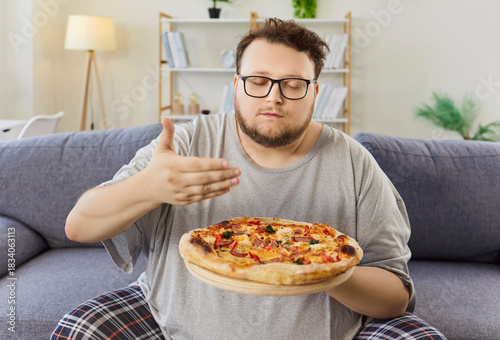 Photos Overweight man resists diet holding pizza