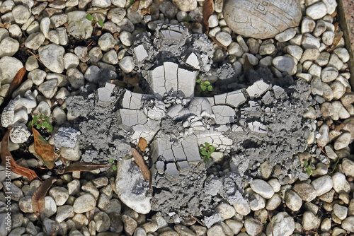 ein graues zerfallendes Kreuz aus Gips