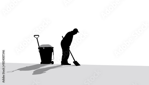 Silhouette of man shoveling snow beside a trash can in winter  