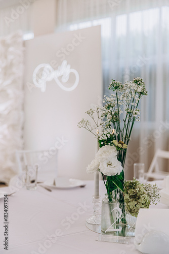 Elegant wedding table setting with white flowers and decorations for a sophisticated celebration.
