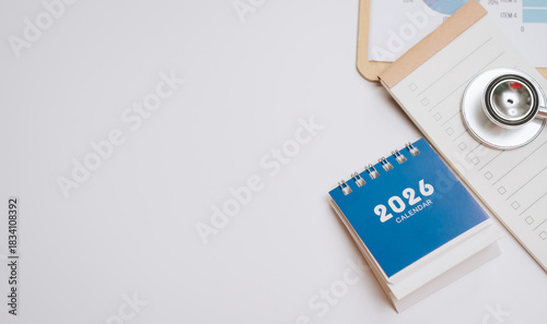 2026 calendar with clipboard and stethoscope on white surface, medical planning and scheduling concept with copy space for text