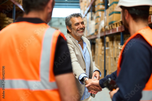 Manager and warehouse worker shaking hands on a deal