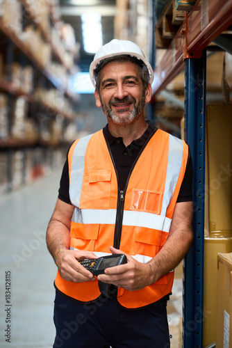 Happy warehouse worker scanning inventory in logistics distribution center