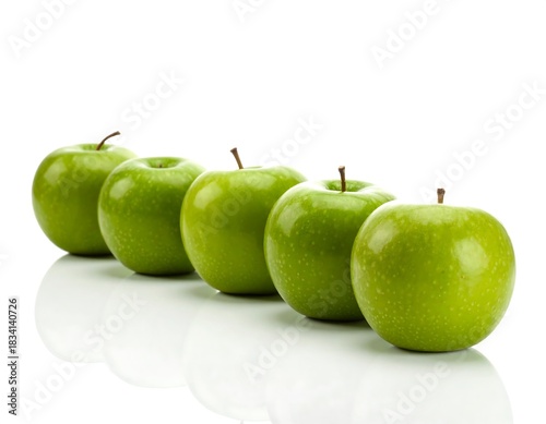 Five green apples aligned in a row, showing light reflections from the surface on a white background