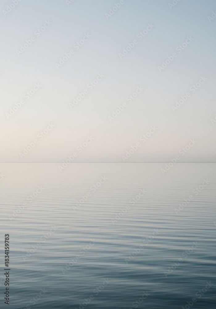 Obraz premium A vast, quiet surface of still water reflecting soft light under a pale sky, evoking deep tranquility and peaceful emptiness, suitable for copy space ,clarity ,soft ,natural