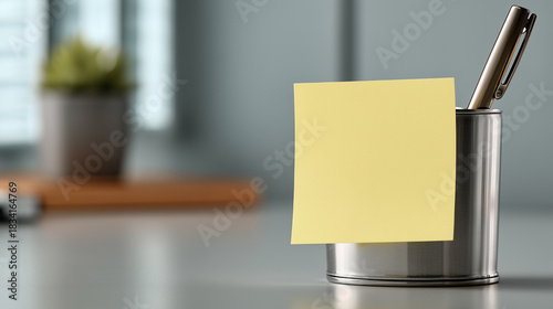 A yellow sticky note is stuck to the side of a pen