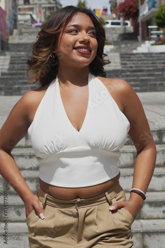 Young woman smiling confidently in white halter top outdoors
