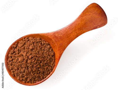 Raw cocoa powder in the wooden spoon, isolated on white background, top view.