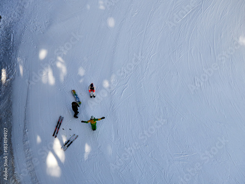 Overhead View of Skiers and Snowboarders on a Groomed Winter Slope
