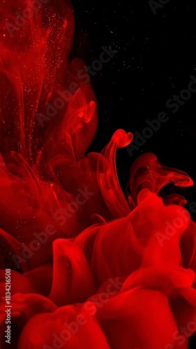 Slow motion macro view of dense, deep red and black fluid ink swirling and mixing creating a majestic cosmic nebula effect deep resonance, smooth, ink in water