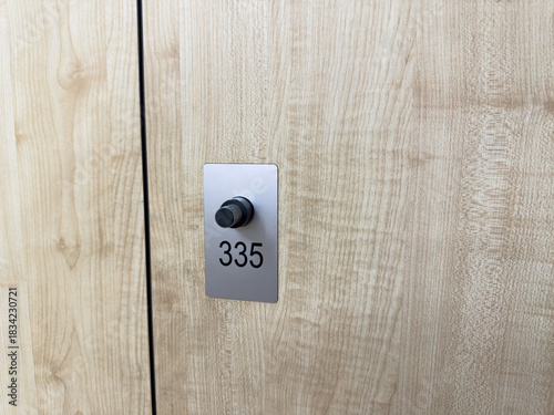 Locker number 315 with modern locking mechanism. Public locker with number in gym locker room with light wood interior. Storage concept for gym locker room during exercise