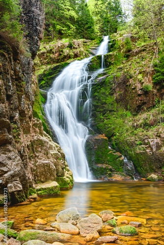 Fototapeta Naklejka Na Ścianę i Meble -  The Giant Mountains, Kamienczyk Waterfall, the highest in the Western Sudetes, the clear water of the stream flows over the rocks. Long exposure on a sunny summer day.