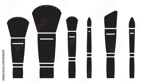  Collection of six black makeup brushes in silhouette against a white background