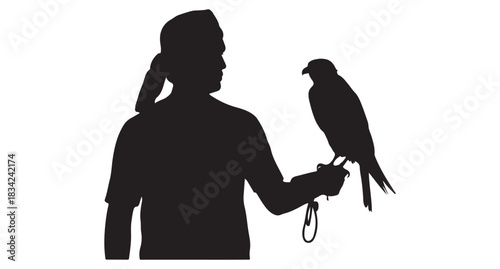  Silhouette of a man in traditional headdress holding a falcon on his gloved hand