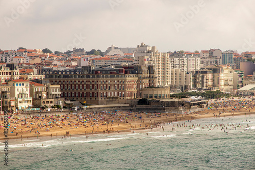 Biarritz, France. Telephoto view of the Hotel du Palais and surrounding buildings, with Miramar Beach crowded below on a summer day, taken from the Biarritz Lighthouse