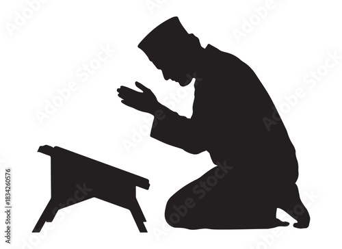  Silhouette of a muslim man praying on his knees beside a wooden stand with his hands raised