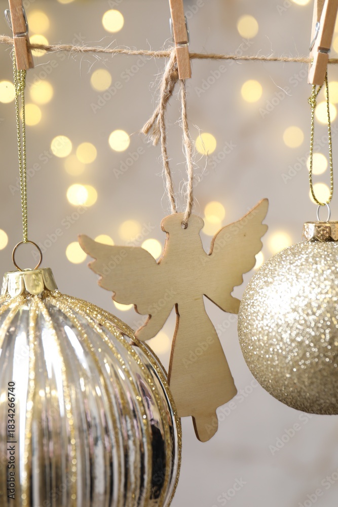 Obraz premium Beautiful Christmas decor hanging on string against blurred lights, closeup