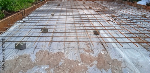 The construction of a concrete foundation using reinforcing steel prepared at the construction site.