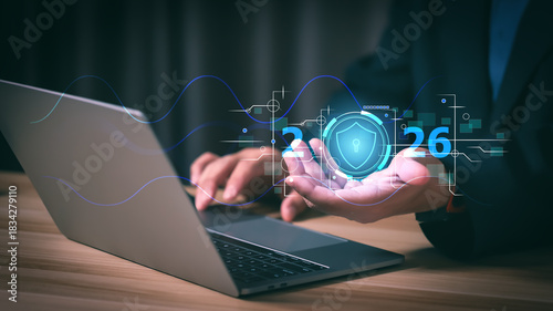 Businessman using laptop with 2026 cyber security interface. Concept of data protection, digital safety, network firewall technology, and privacy system for future corporate business strategy.