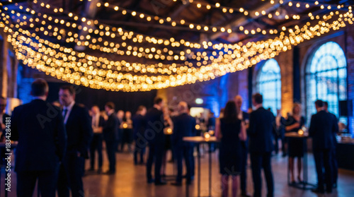 Blurred background of a busy corporate networking event with warm festive bokeh lights and people mingling.