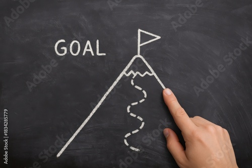 Hand pointing at a drawn mountain with a flag labeled 'GOAL', symbolizing aspiration, achievement, and the journey towards success. Concept of motivation and personal development.