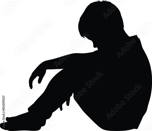 Silhouette of a sad boy sitting alone