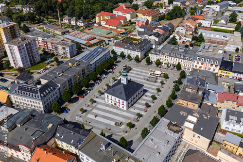 Aerial drone view of Jesenik town in Czech Republic showcasing the central market square and historic buildings nestled in Jeseniky Mountains, panoramic urban landscape in sunny summer day