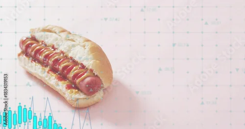 Fototapeta Displaying single hot dog resting on pastel pink grid tabletop showing mustard ketchup, teal charts