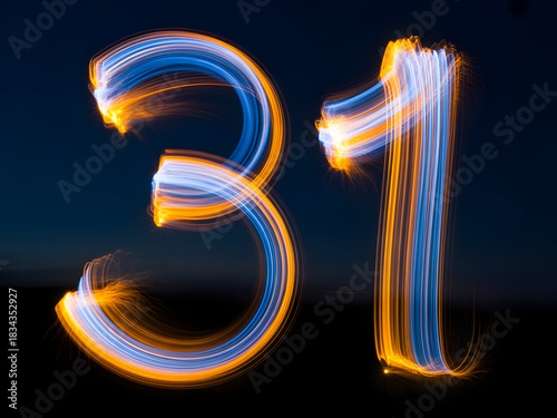 Number thirty one formed by glowing blue and orange light trails against a dark night sky background