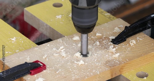 DIY reclaimed wood, drilling hole at wood plank using battery powered electric drill and forstner bit, close up