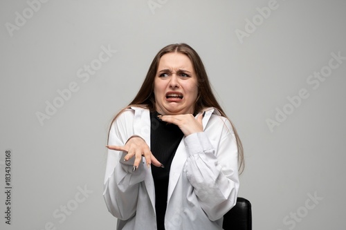 Photos Woman reacting with disgust and fear, making dramatic expressive face in studio