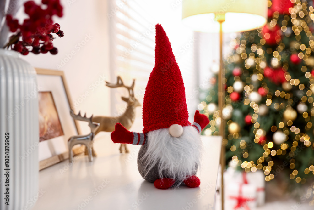 Obraz premium Funny Christmas gnome on cabinet in decorated room