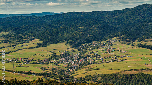 Fototapeta Naklejka Na Ścianę i Meble -  Aerial View Of Mountain Village In Green Valley With Rolling Hills