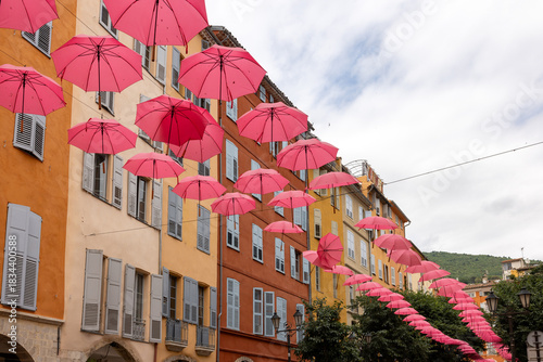 Fototapeta Naklejka Na Ścianę i Meble -  Streets of Grasse, a city known for its perfumery, decorated with pink umbrellas on the occasion of the annual international exhibition of roses - Expo Rose.