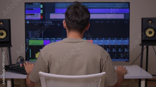 Music producer manipulates faders and displays in dimly lit home studio, Creative audio engineer calibrates channel strips and meters during detailed mixing session