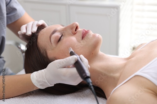 Quadro su tela Woman undergoing microneedling procedure in beauty salon, closeup