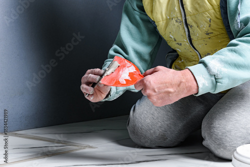 Applying fugue on ceramic tiles with a spatula.