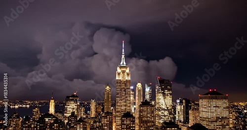 Experience New York City's electrifying skyline at night with an approaching storm, lightning flickering behind iconic buildings and vibrant city lights