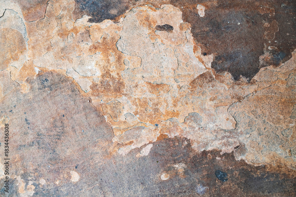 Obraz premium Abstract top-down view of natural slate stone texture with varied shades of orange, brown, and grey, perfect for a background.