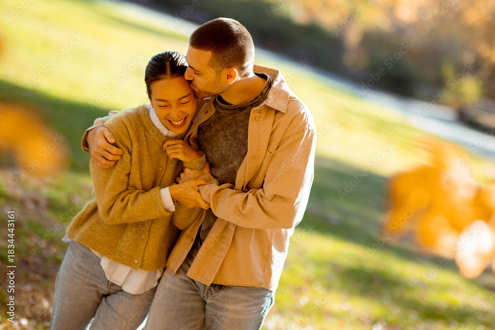 Fototapeta premium Couple enjoying warm moments together in a vibrant autumn park