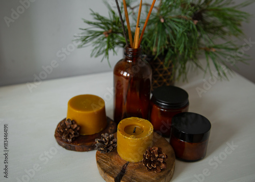 Wax candles on a wooden candlestick near green Christmas fir tree branch. Closeup ornament holiday background concept with white empty copy space. Natural day light