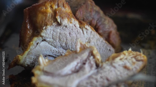 macro of fork taking a cut appetizing prepared piece of meat from the baking sheet, consumption of fatty meat, macro pork meat dishes