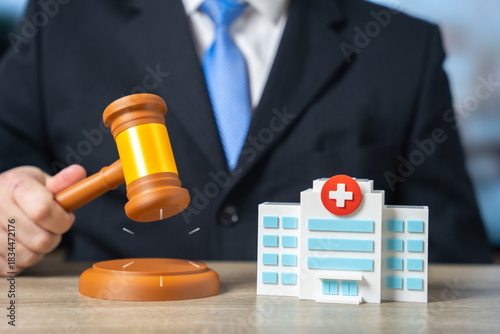 Картината върху платно A man with a judge's gavel and a hospital building