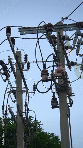 industrial power distribution setup with technicians inspecting cables and insulators in daylight
